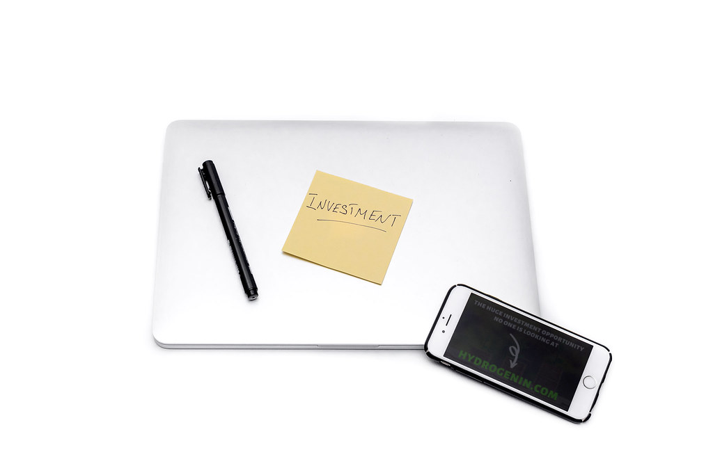 Laptop and smartphone showing financial applications on a home desk